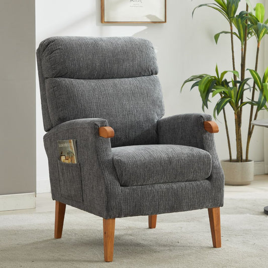 Gray armchair with wooden legs in a room with a plant and framed picture.