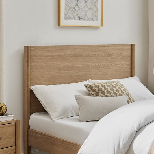 Wooden bed with white bedding and decorative pillows in a bedroom setting.