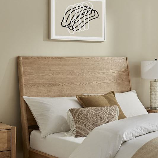 Bedroom with wooden headboard, white bedding, and decorative pillows.