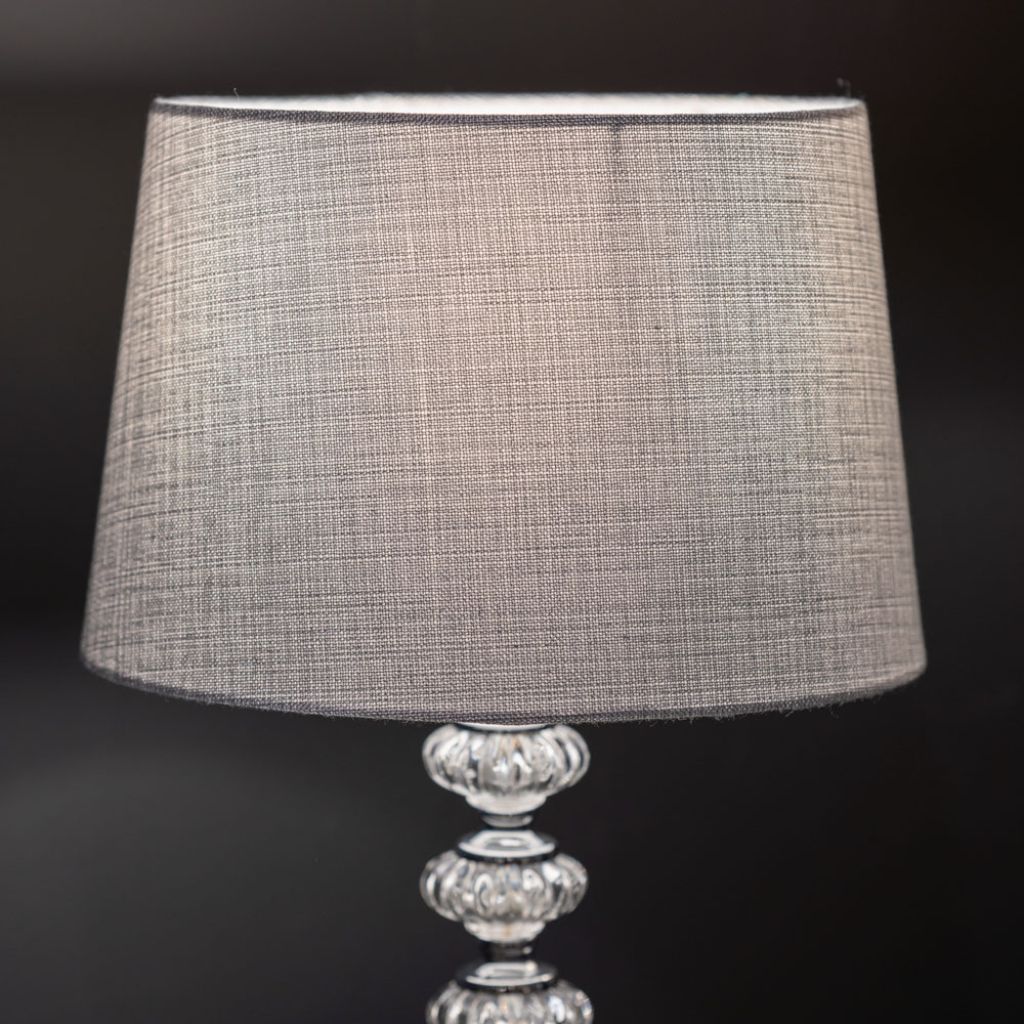 Lamp with a textured gray shade on a dark background