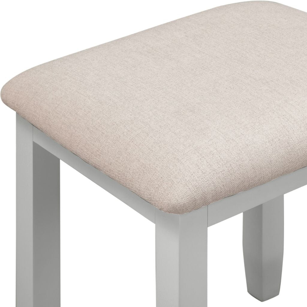 Grey dressing stool with beige cushion on a white background