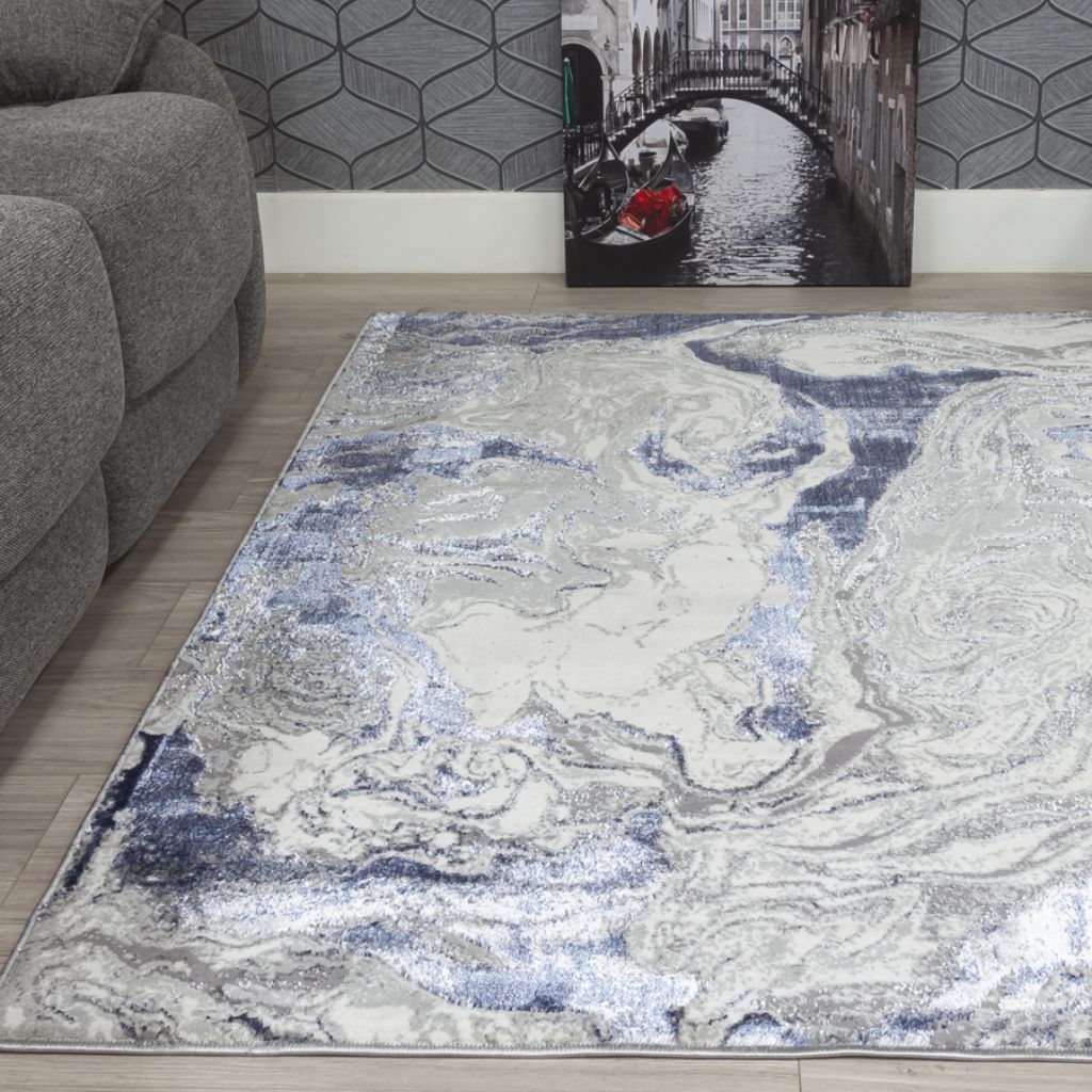 Marble-patterned rug on a wooden floor with a gray sofa and wall art in the background.