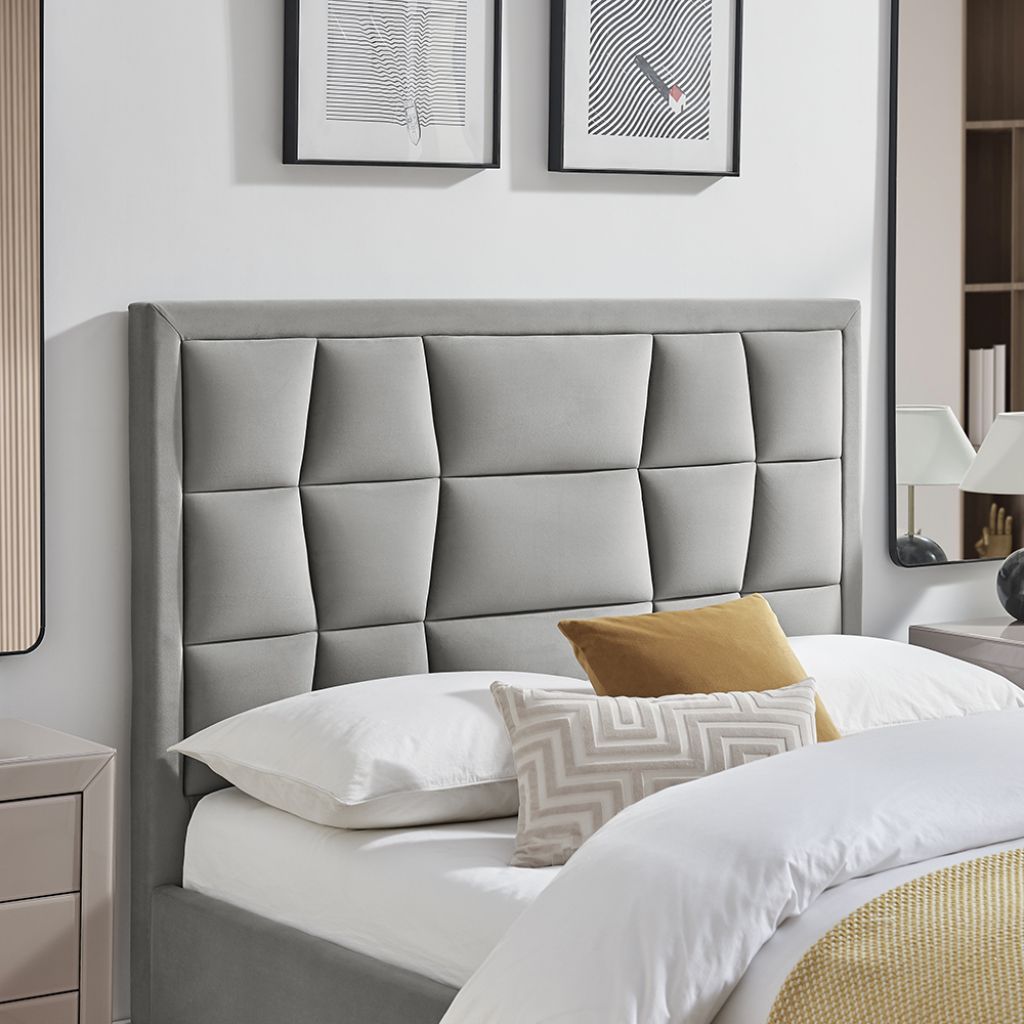 Gray upholstered headboard with pillows in a bedroom setting