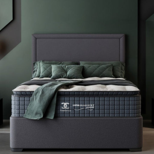 Gray bed with green bedding in a room with a dark green wall.