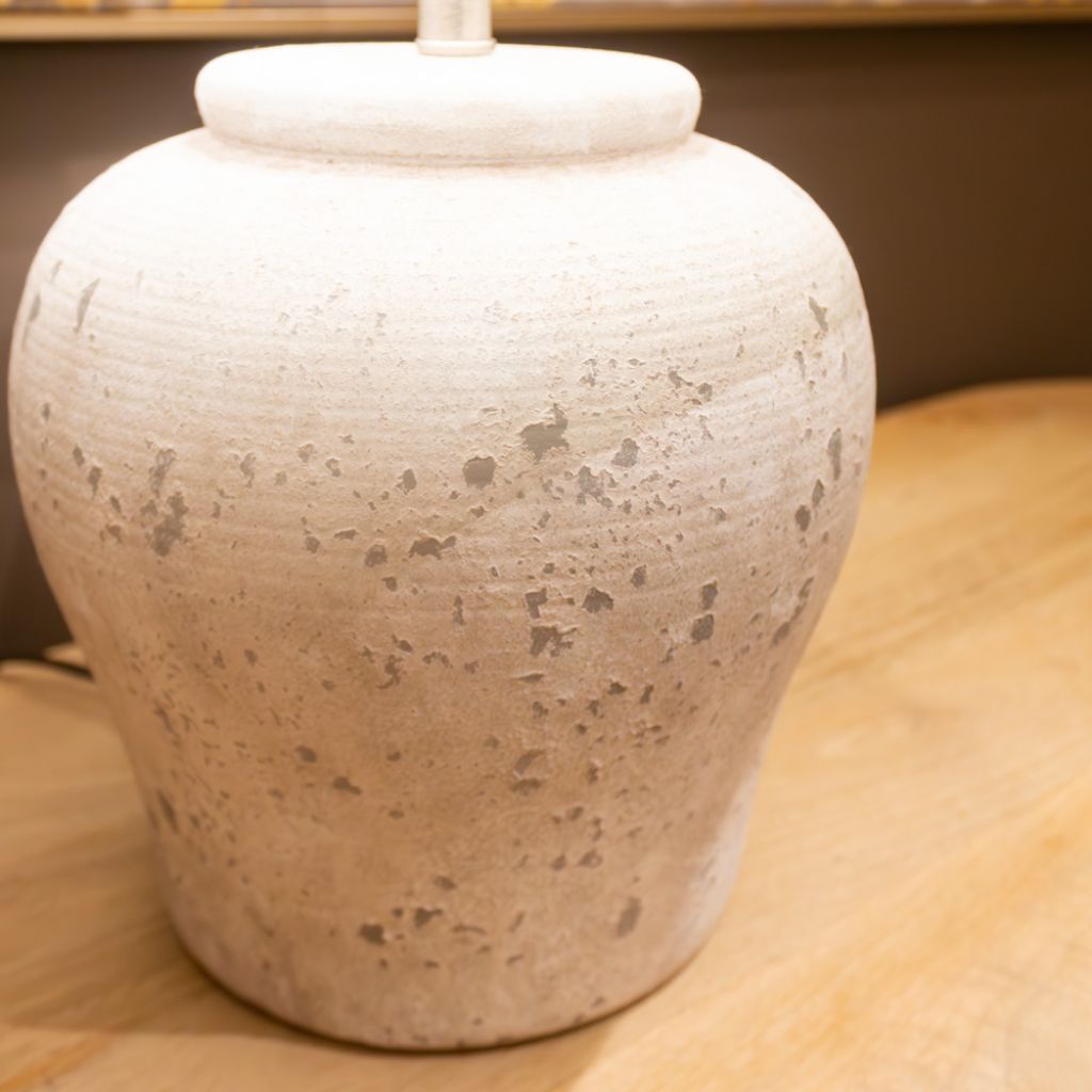 White ceramic jar with textured surface on a wooden surface