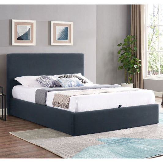 Navyupholstered bed in a room with gray walls, a plant, and a rug.