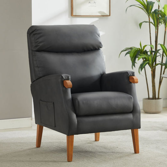 Gray fireside chair with wooden legs in a room with a plant and framed picture on the wall.
