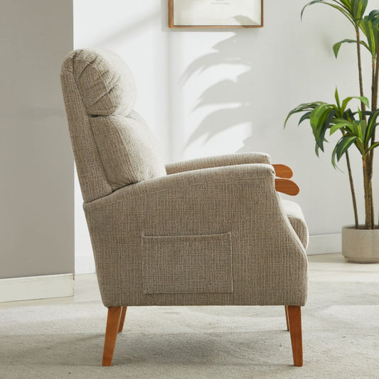 Beige armchair in a room with a plant and framed picture on the wall