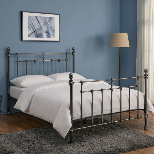 Bedroom with a metal bed frame, white bedding, and a lamp against a blue wall.