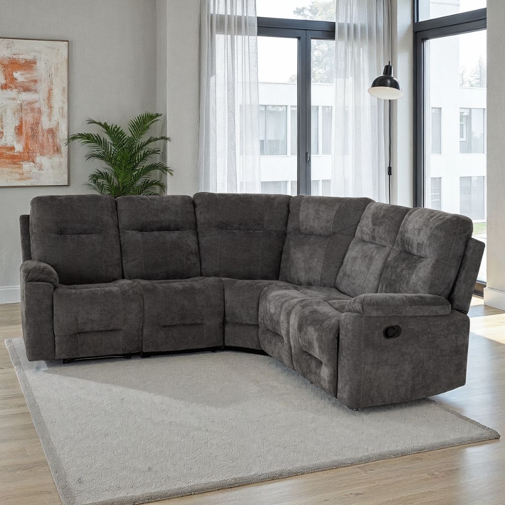Grey sectional sofa in a living room with large windows and a plant.