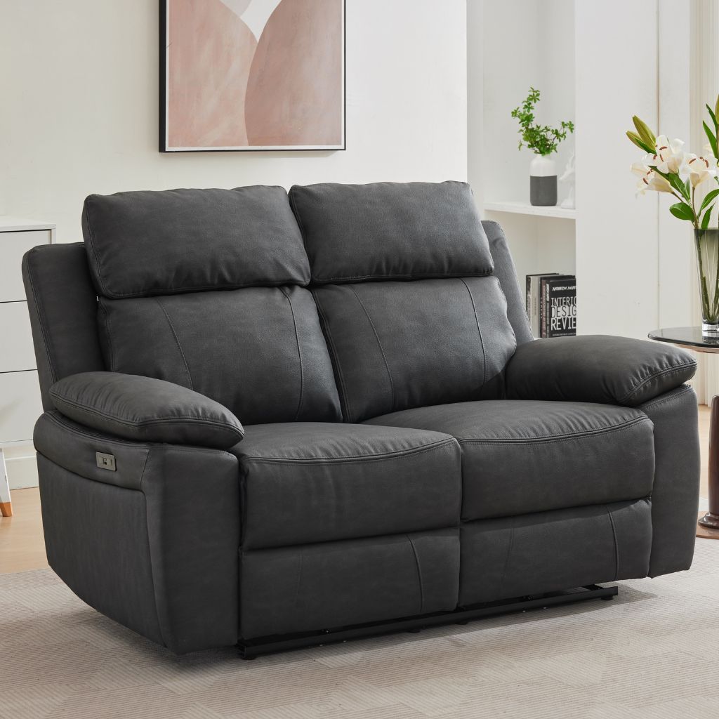 A dark grey fabric reclining sofa shown in a modern living room setting.