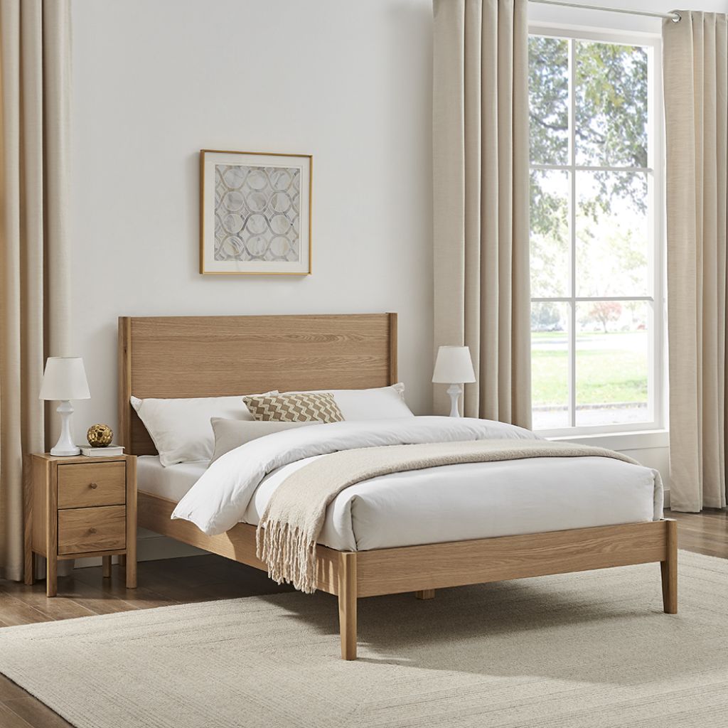 Wooden bed in a bedroom with white bedding and side tables.