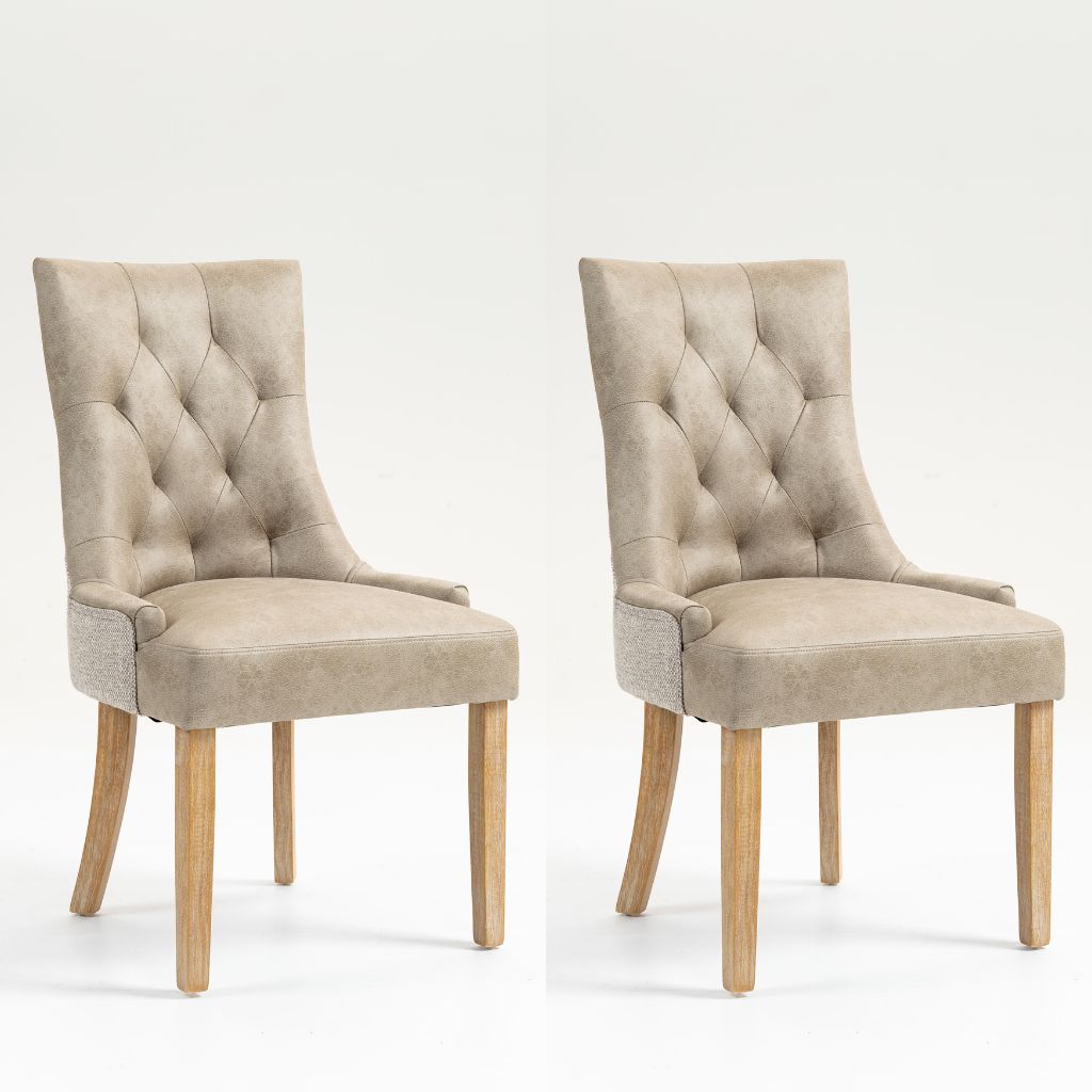 Two matching upholstered dining chairs with tufted backs, light beige fabric seats, and natural wood legs.