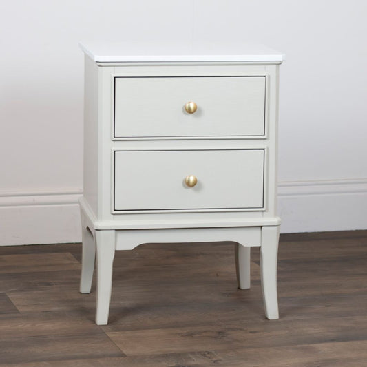 Stone nightstand with two drawers and gold handles on a wooden floor.