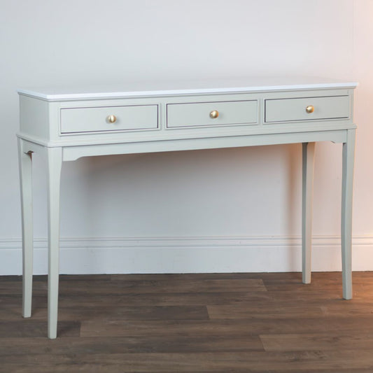 Stone console with three drawers on a wooden floor against a white wall
