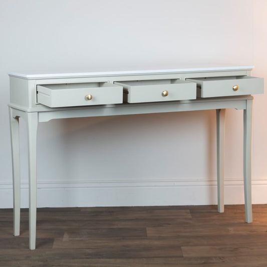 Stone console table with three drawers on a wooden floor.