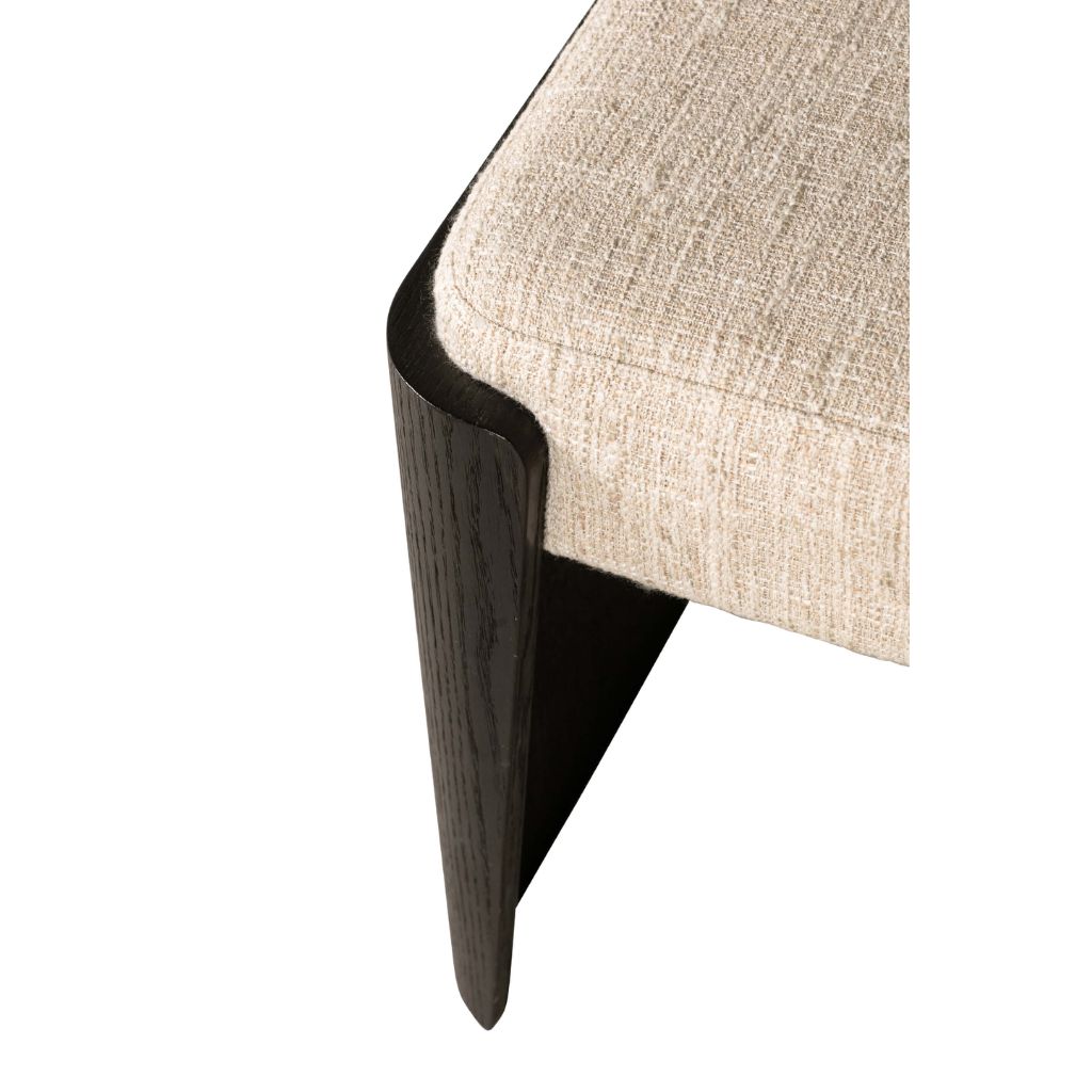 Close-up of a corner where a black and wood-textured surface meets a beige fabric surface.
