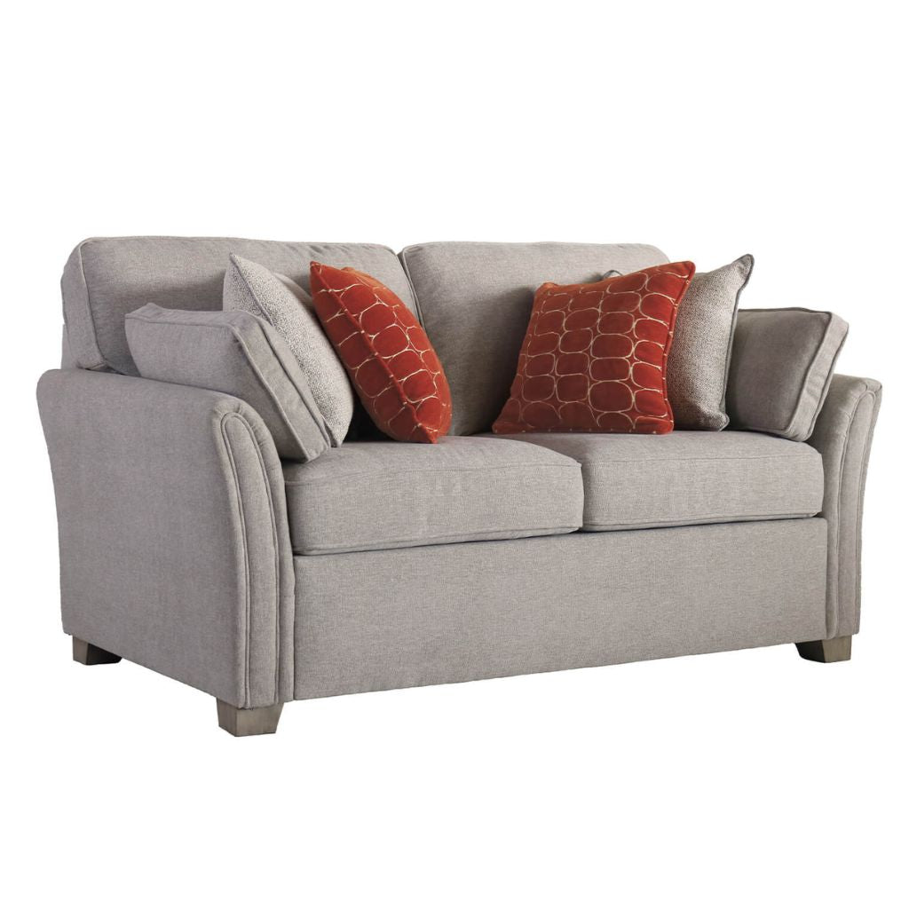Natural sofa with red and natural patterned cushions on a white background